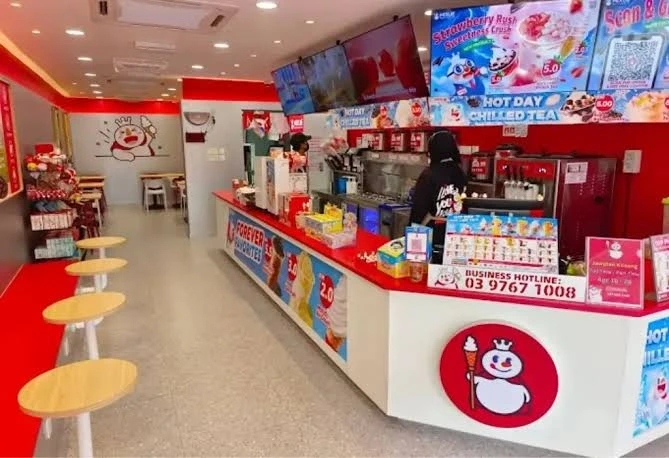 Mixue franchise outlet interior in Malaysia with red counter, ice cream machines and seating
